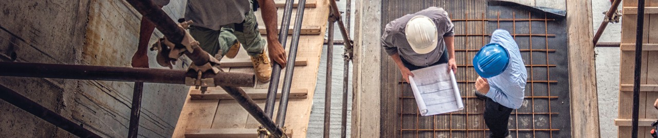 Man looking at blueprints on construction site